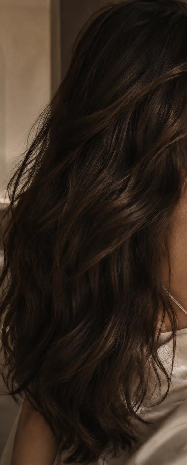 Long, dark brown waves falling past the shoulder